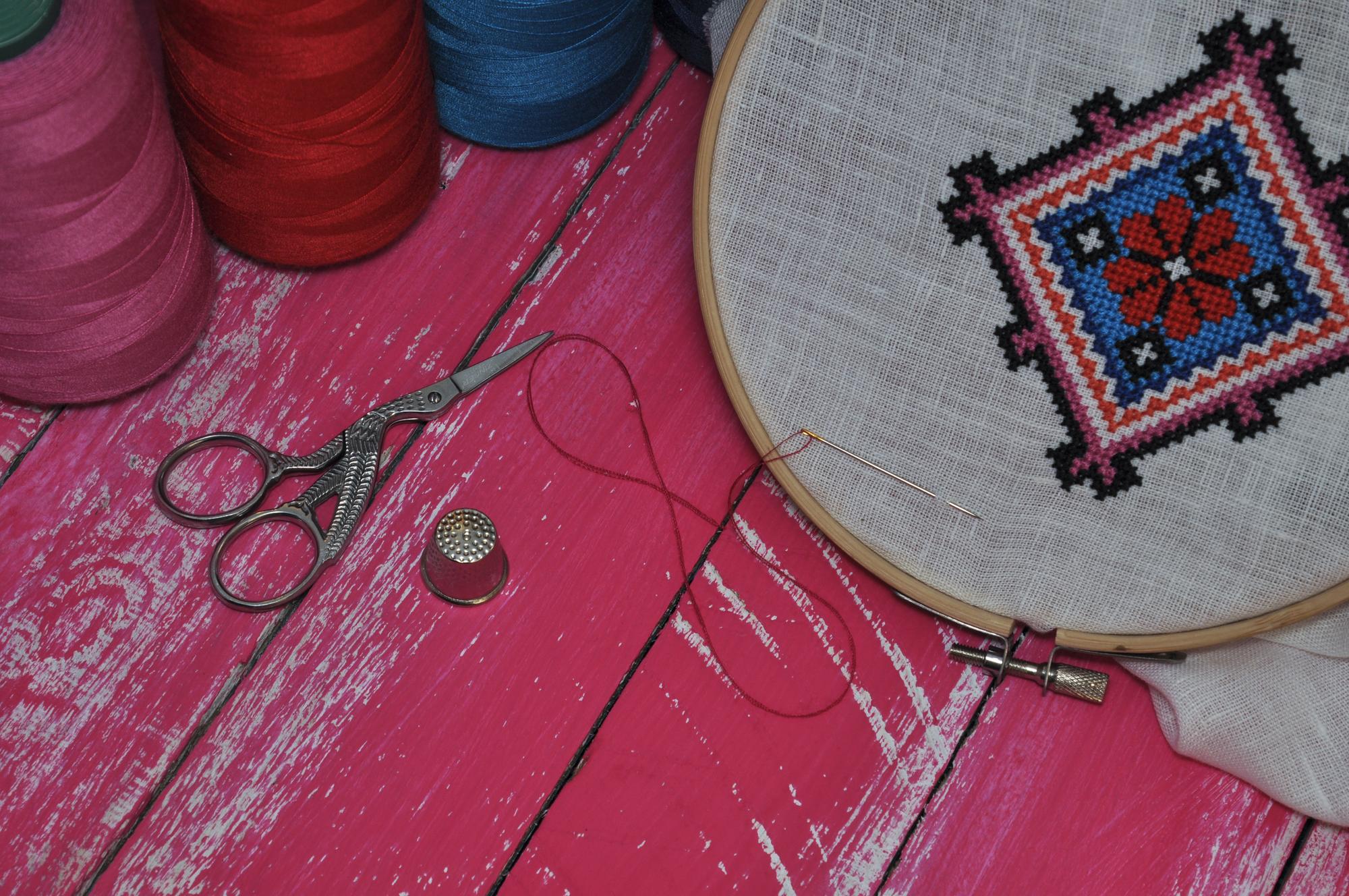 Workshop table with threads and finished embroidered patches